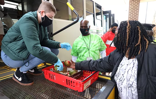Carolyn MIller, left, helps Melody Hickman choose a mango during a recent Foodlink Curbside Market visit to Kennedy Tower. - PHOTO BY MAX SCHULTE