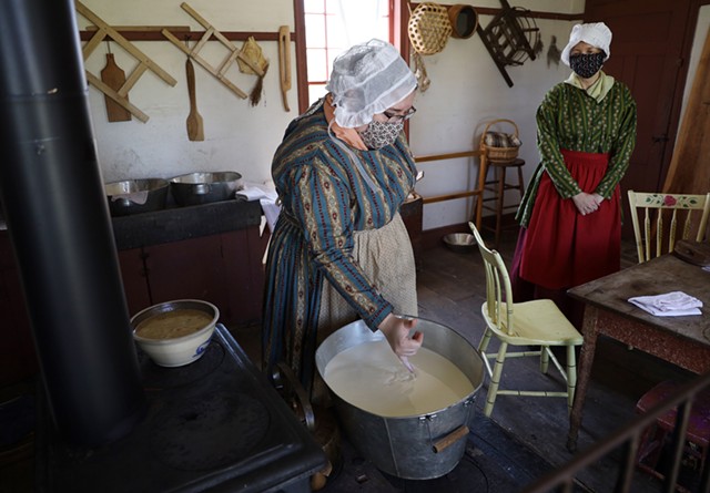Historic interpreters engaged in an old process of cheese-making, in an 1830s farmhouse kitchen at Genesee Country Village & Museum. - PHOTO BY MAX SCHULTE