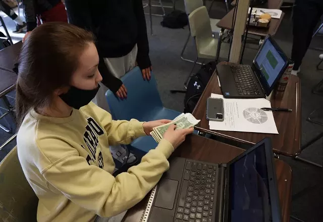 During her lunch break, Hilton High School senior Olivia Bartek counts the money she earned working at a pizza shop to pay for an application to a college. - PHOTO BY MAX SCHULTE