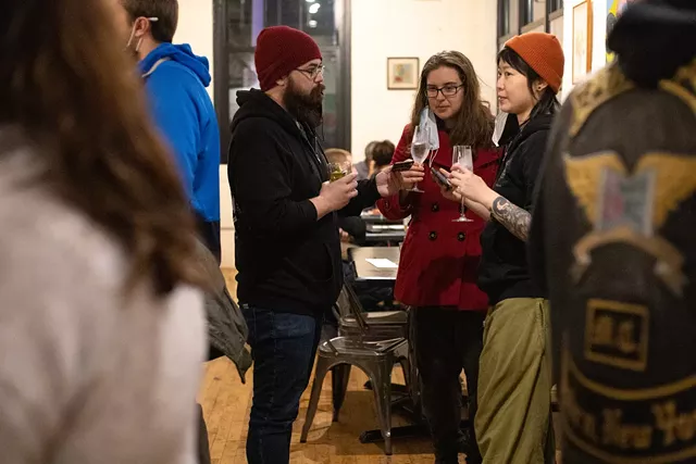 Robb Heffner (in red hat) and Cat Hsu (in orange hat) of Happy Gut Sanctuary and a friend try drinks from AltBar's zero-proof cocktail menu at a pop-up event at Fuego. - PHOTO BY QUAJAY DONNELL