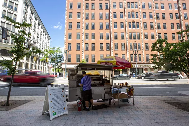 When Charlie unfurls the red and yellow umbrella on his cart in the morning, it isn't long before customers from nearby office buildings begin to descend on him to sample his eclectic menu. His is the only cart in town that offers french fries. - PHOTO BY LAUREN PETRACCA