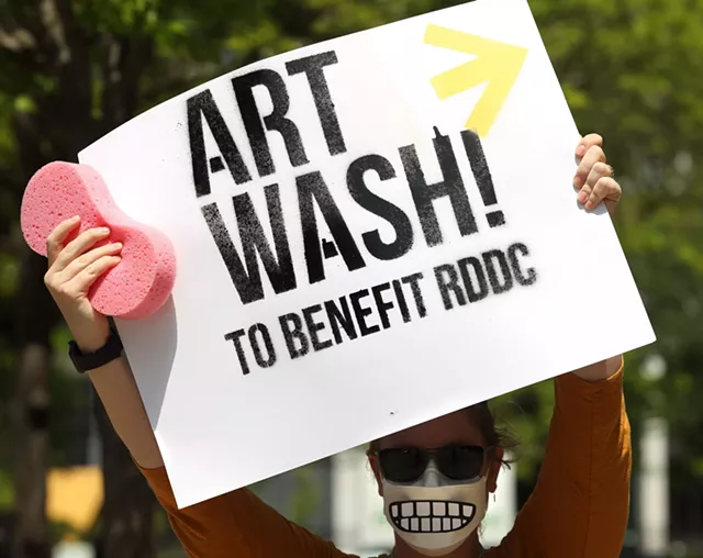 Nicole Bruno protests Rochester Downtown Development Corp.’s push for a business improvement district - outside a meeting of the agency at the Holiday Inn. - PHOTO BY MAX SCHULTE