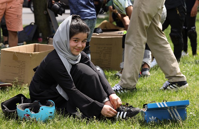 Shamila ties up a pair of skate shoes for Rolling Resettlement's outing to the Roc City Skatepark. - PHOTO BY MAX SCHULTE