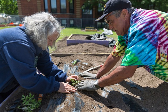 Members of the Marketview Heights Collective Action Project grow food, flowers, and community. - Judy Douglas and Martin Pedraza tend one of the neighborhood's gardens. - PHOTO BY AUDREY HORN
