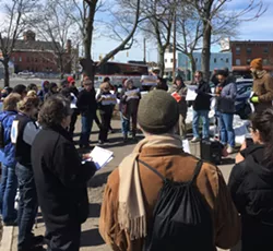 Justin Delinois, an organizer with UR DREAMers, addresses a crowd of about 40 people outside of the Rochester Greyhound and New York Trailways station. - PHOTO BY JAKE CLAPP