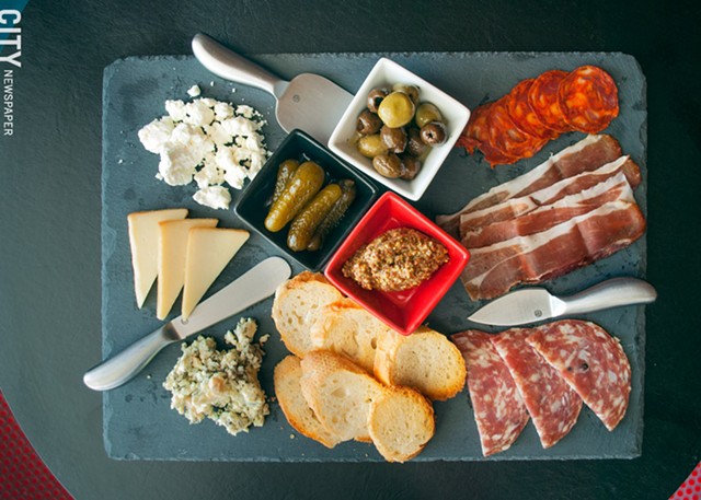 Bliss's charcuterie board is loaded with three types of meat, three types of cheese, bread, olives, gherkins, and mustard. - PHOTO BY RENÉE HEININGER