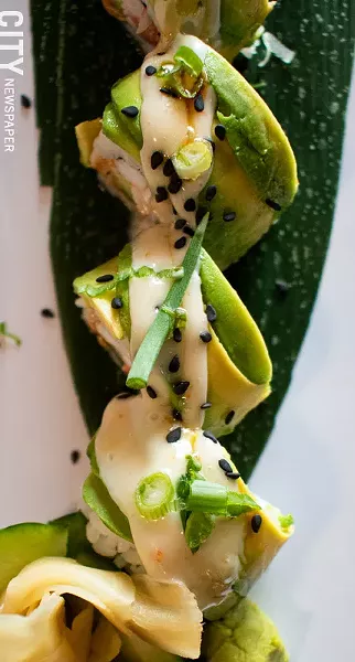 The Johnny Cashew roll consists of smoked salmon, steamed shrimp, cashew butter, and cucumber, and then topped with avocado, eel sauce, and sprinkled with black sesame and scallions. - PHOTO BY JACOB WALSH