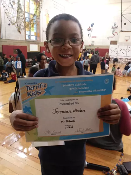 Windom's 8-year-old son, Jeremiah, holds up an award for positive attitude, good character, and responsible citizenship. - PHOTO PROVIDED