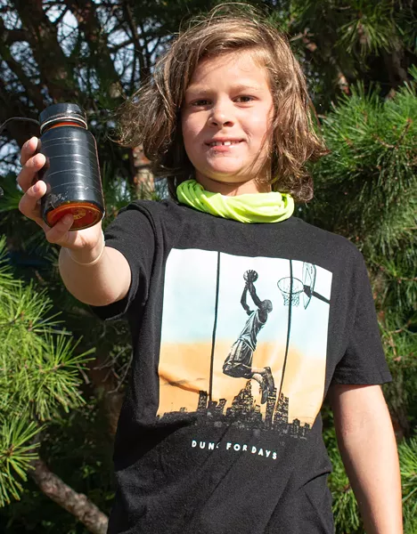 Geocacher Rhys Dawson with the cache outside of The Little Theatre in downtown Rochester. - PHOTO BY JACOB WALSH