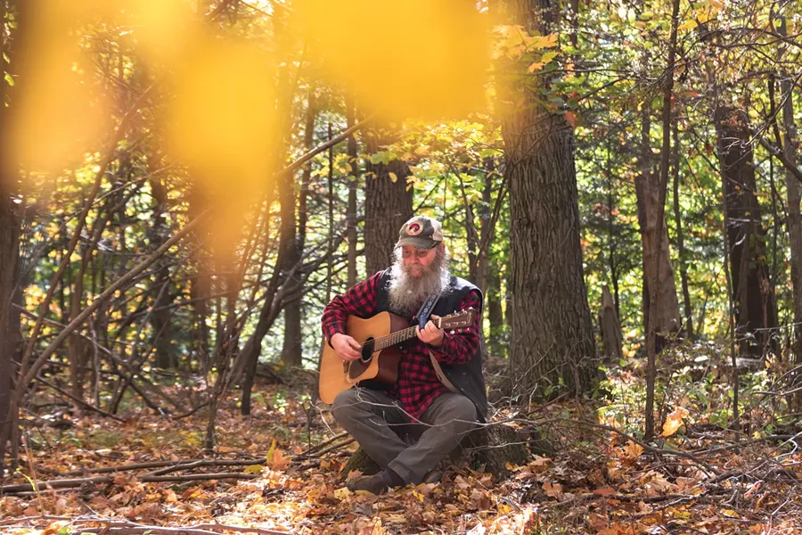 Bob Bunce plays the guitar on his rural property near Groveland, New York. - PHOTO BY RYAN WILLIAMSON