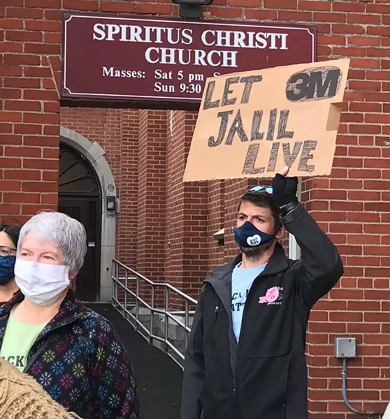 A supporter of Jalil Muntaqim holds aloft a sign at a rally calling for authorities to drop the voter fraud charges against him. Nov. 12, 2020. - PHOTO BY DAVID ANDREATTA