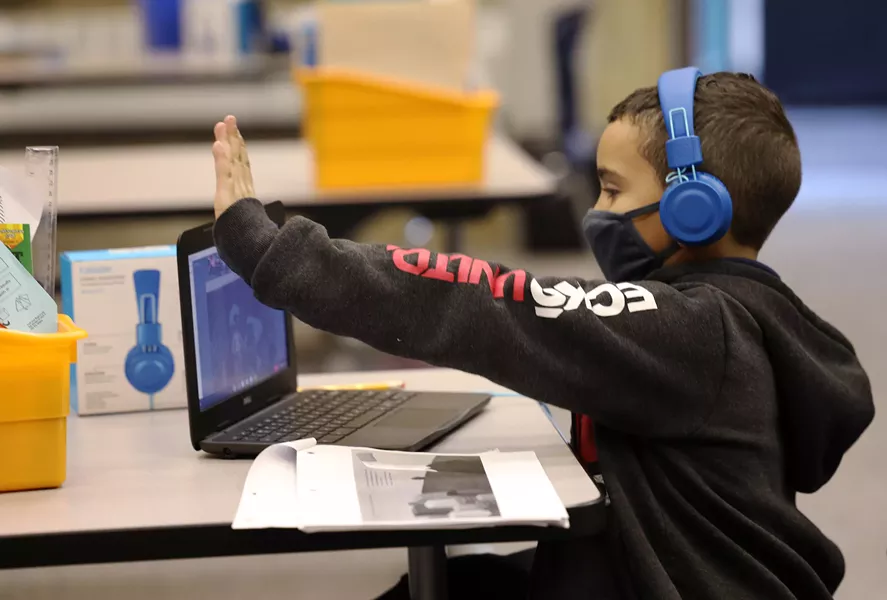 Dante Flores gives his class a virtual high-five after completing a discussion about a story his class read. - PHOTO BY MAX SCHULTE / WXXI NEWS