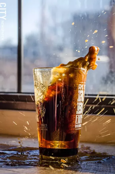 The workers at Joe Bean drop a shot of espresso into a half pint of porter for its 'Spro Bomb. - PHOTO BY MARK CHAMBERLIN