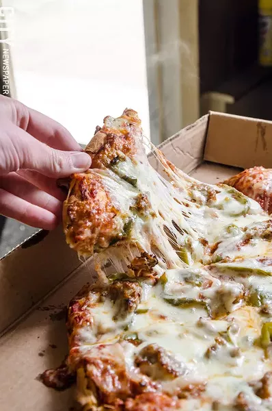 Thick crust pizza from Nino's topped with peppers, onions, and sausage. - PHOTO BY MARK CHAMBERLIN