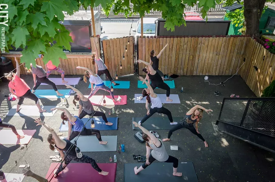 A yoga class during a session in the back of The Daily Refresher. - PHOTO BY MARK CHAMBERLIN