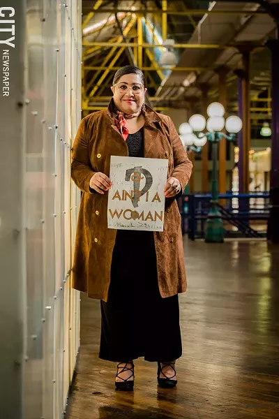 Rachel Y. DeGuzman holds a work by Rochester artist Amanda Chestnut, who created the piece for the recent 21st Century Arts event "And, Ain't I a Woman: A Long Table Conversation and Installation." - PHOTO BY JOSH SAUNDERS