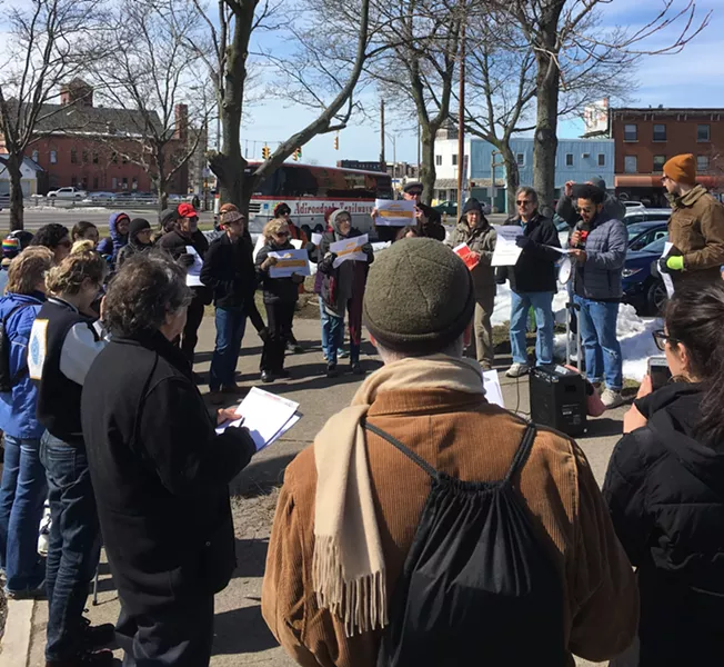 Justin Delinois, an organizer with UR DREAMers, addresses a crowd of about 40 people outside of the Rochester Greyhound and New York Trailways station. - PHOTO BY JAKE CLAPP