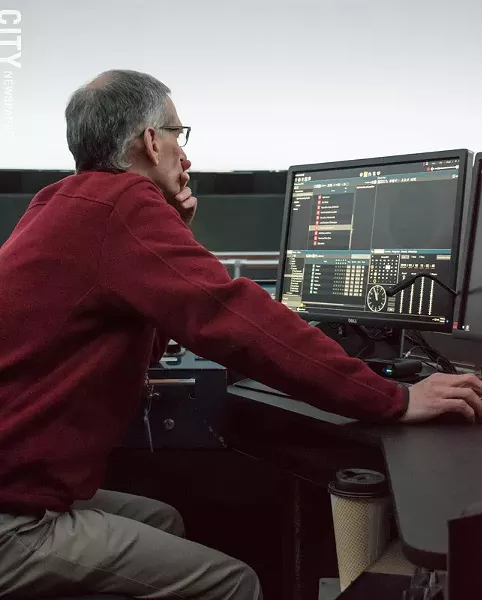 Planetarium director Steve Fentress tweaks details in Star Theater's control booth. - PHOTO BY JACOB WALSH
