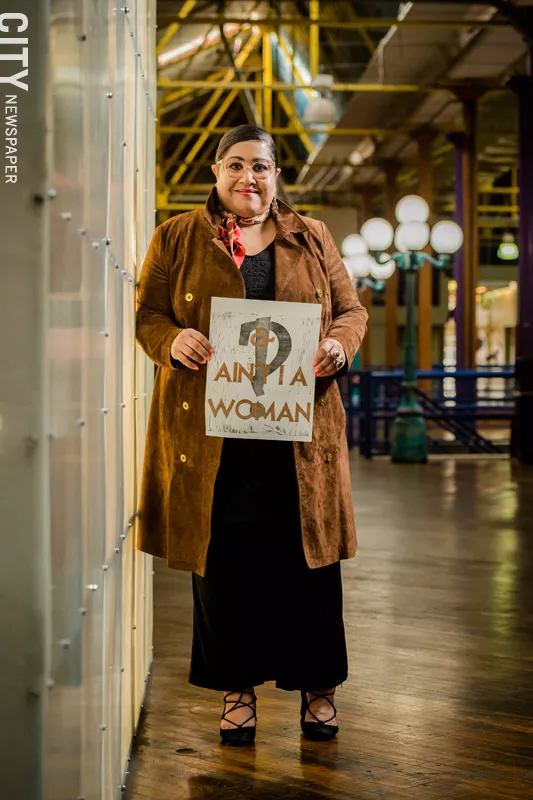 Rachel Y. DeGuzman holds a work by Rochester artist Amanda Chestnut, who created the piece for the recent 21st Century Arts event "And, Ain't I a Woman: A Long Table Conversation and Installation." - PHOTO BY JOSH SAUNDERS