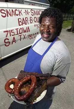 Bar-B-Que's best friend, Paul Brooks, displays some of his mesquite-smoked victuals outside the North New Braunfels Avenue location of Snack & Smack Bar-B-Que.