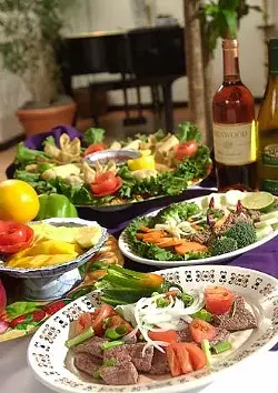 Clockwise from front: Larb Nuah (finely chopped lean beef marinated with onion, fish sauce, lime, roasted ground rice, and cilantro); fresh fruit tray; spring rolls, egg rolls, and crab rangoon; hot pepper beef stir-fried with garlic, onion, tomato, and hot peppers.