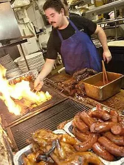 David Palacios works the grill at Tom's Ribs on Nacogdoches. All of the meats are smoked twice, bathed in sauce, and then finished on the grill prior to being served.