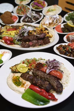 Jerusalem Grill’s kafta kabob served with grilled vegetable rice and salad garnish.