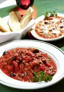 The Red Snapper Piccolo (front) in a sauce of tomato, black olives, capers, pine nuts, and white raisins accompanied here with the funghi grattinatia appetizer.