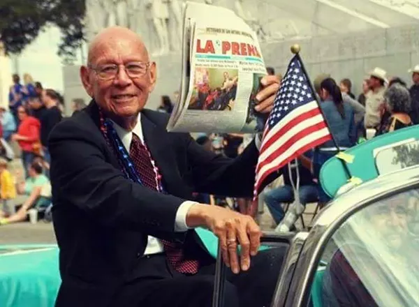 Tino Duran shows off a copy of La Prensa while participating in a Fiesta parade. - COURTESY