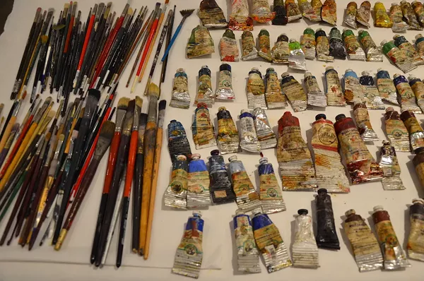 Paints and brushes in Ana Fernandez’s workspace - PHOTO BY BRYAN RINDFUSS