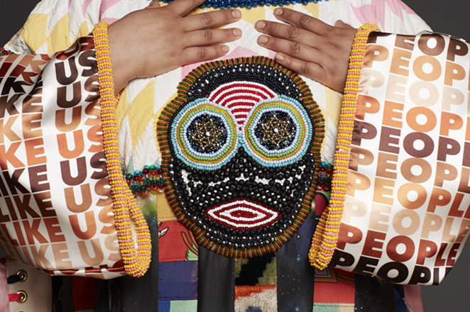 Jeffrey Gibson. PEOPLE LIKE US, 2018. Custom-printed polyester satin and neoprene, cotton, silk Ikat velvet, wool, repurposed quilt, tapestry, and vestment, with glass, plastic, and stone beads, nickel and brass studs, brass grommets, cultured pearls, nylon ribbon, and artificial sinew on canvas, suspended from tipi poles with rawhide ties, 85 x 74 x 5 in. Courtesy of the artist; Roberts Projects, Los Angeles; Sikkema Jenkins & Co., New York; and Kavi Gupta, Chicago. - CAITLIN MITCHELL // COURTESY OF THE RUTH AND ELMER WELLIN MUSEUM OF ART AT HAMILTON COLLEGE.
