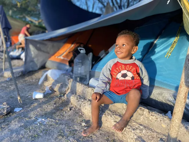 A child waits in a sleeping shelter at the Matamoros border camp. - TWITTER / @CLARAB_KGBT