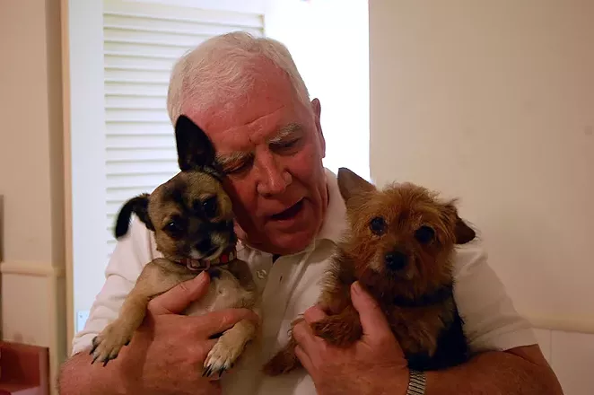 Father Jim Hynes with two of the strays he adopted. - MICHAEL MARKS