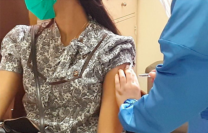 A volunteer holds still for a COVID-19 vaccine during a clinical trial. - WIKIMEDIA COMMONS / RIO TUASIKAL