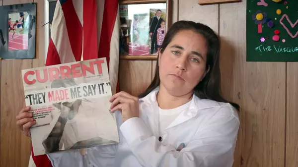 A still from the documentary film Southwest of Salem of Anna Vasquez holding a 2012 issue of the San Antonio Current featuring a cover story about the case of the San Antonio Four. - MOTTO PICTURES AND NAKED EDGE FILMS