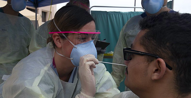 A medical technician swabs a patient at a COVID-19 testing site. - WIKIMEDIA COMMONS / U.S. NAVY