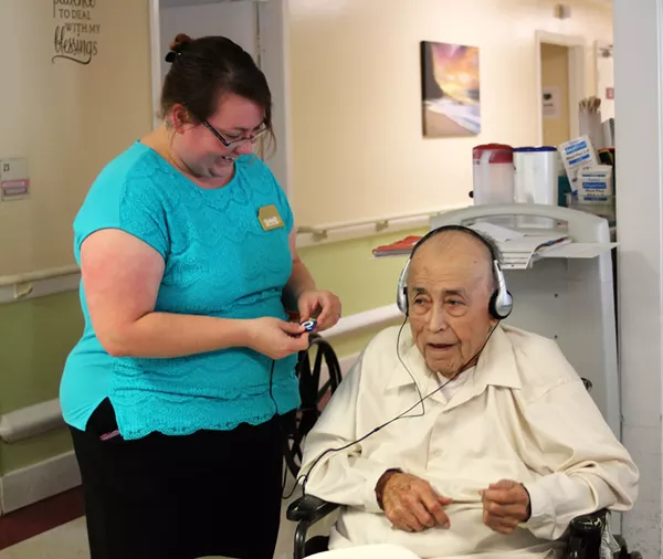 Stonebrook Manor's Activity Assistant helps Mr. Gallegos listen to his favorite, conjunto. - TIM SLUSHER