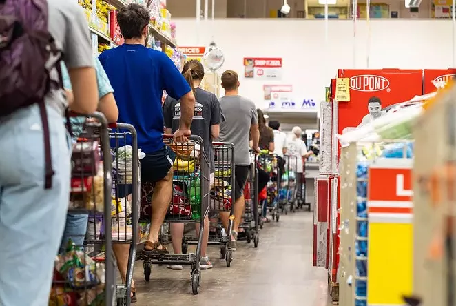 Grocery shoppers formed a long line at the H-E-B grocery store at Hancock Center in Austin last year. Grocery store employees were called essential when the pandemic began, but haven't been given priority access to the coronavirus vaccine. - TEXAS TRIBUNE / JORDAN VONDERHAAR