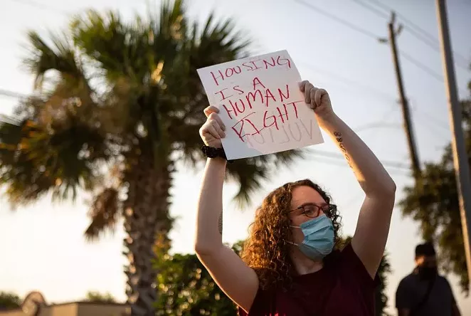 A demonstrator held up a sign in protest of evictions at the Harris County Courthouse in Houston on Aug. 21. - PU YING HUANG / THE TEXAS TRIBUNE