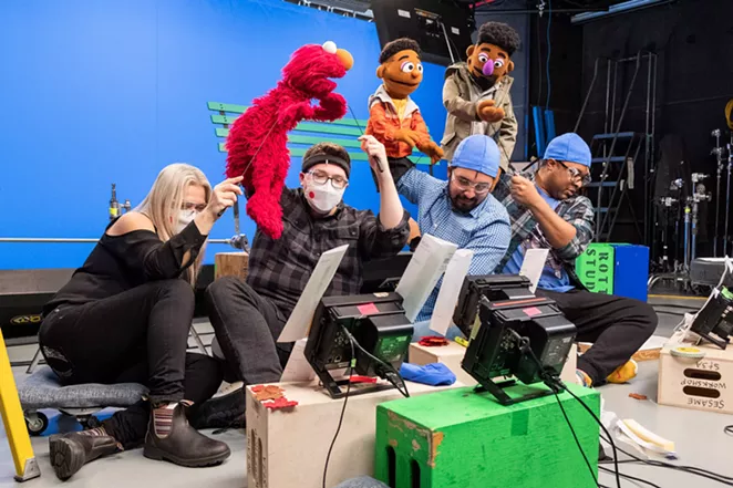 Bradley Freeman Jr. (second from right) controls the Wesley Walker Muppet during a shoot for a Sesame Street online series. - SESAME WORKSHOP
