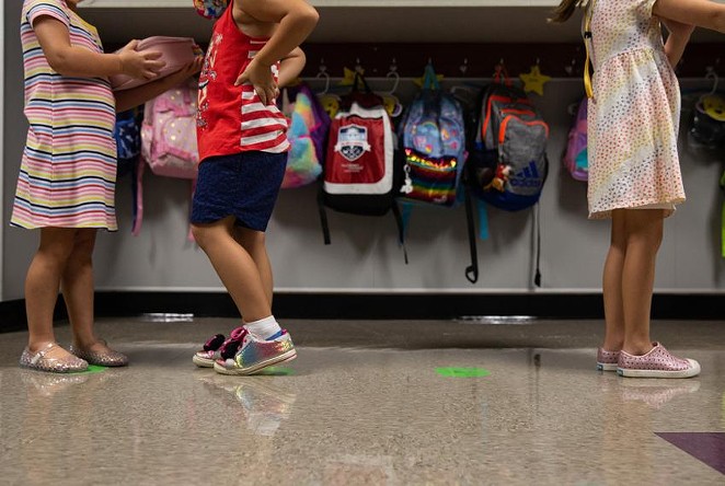 Kindergarten students line up on social distancing markers on the first day of in-person classes at Highland Village Elementary last year. - TEXAS TRIBUNE / SHELBY TAUBER