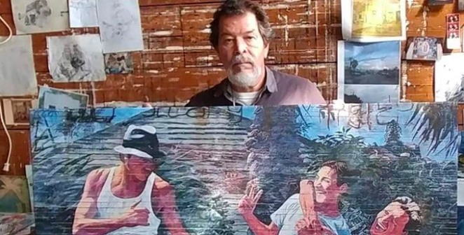 Adan Hernanez holds up one of his paintings in a photo shared on a GoFundMe account set up to cover his funeral expanses. - GOFUNDME / ARMANDO HERNANDEZ