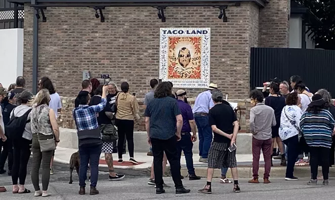 Taco Land regulars gather around a mosaic honoring the club's owner, the late Ram Ayala, on Thursday evening. - SANFORD NOWLIN