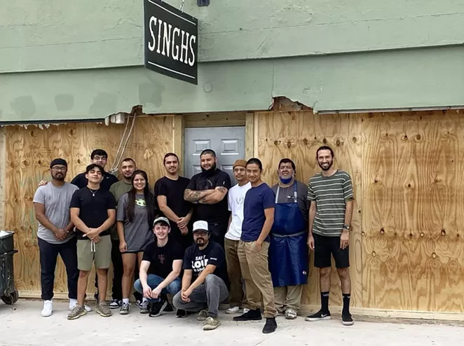 Employees of Singh's Vietnamese pose in front of the restaurant's now boarded-up storefront. - INSTAGRAM / SINGHS_SA