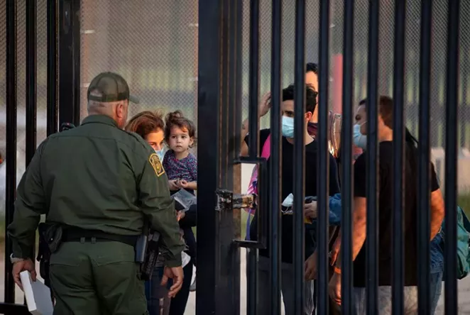A group of migrants wait to turn themselves over to National Guard and Customs and Border Patrol officials at the U.S. and Mexico border in Del Rio on July 22, 2021. - TEXAS TRIBUNE / MIGUEL GUTIERREZ JR.