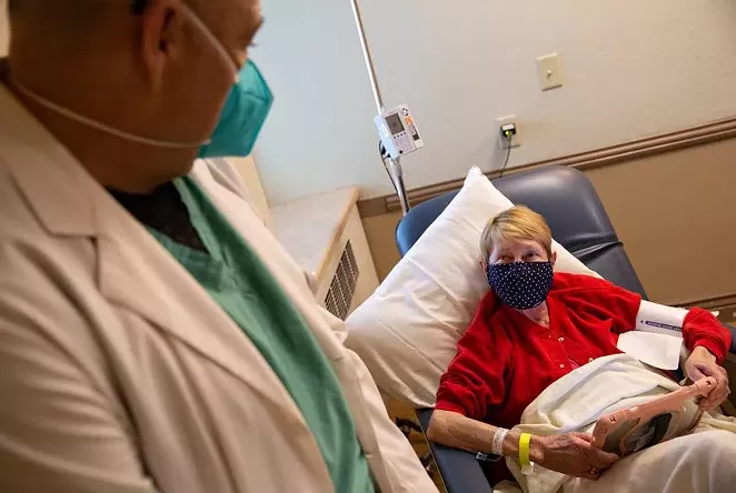 Dr. Fritz Thurmond speaks to Kathy Hardman during a one-hour observation period after receiving a COVID-19 antibody infusion Aug. 19 at Titus Regional Medical Center in Mount Pleasant. - TEXAS TRIBUNE / SHELBY TAUBER