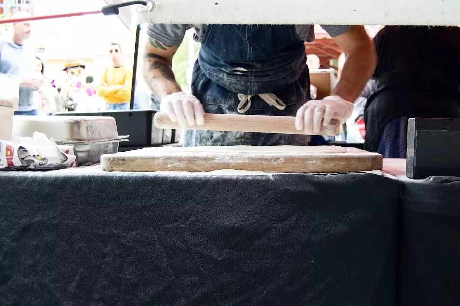 Grimes cuts the dough into squares before handing them off to the fryer. - LEA THOMPSON