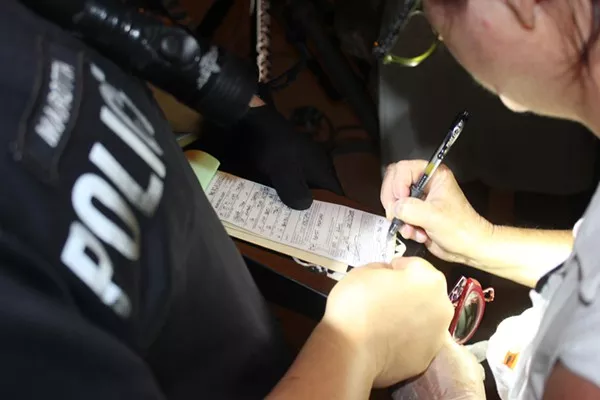 Joan Cheever signs a citation issued to her on April 7. - DAVID MARTIN DAVIES/TEXAS PUBLIC RADIO