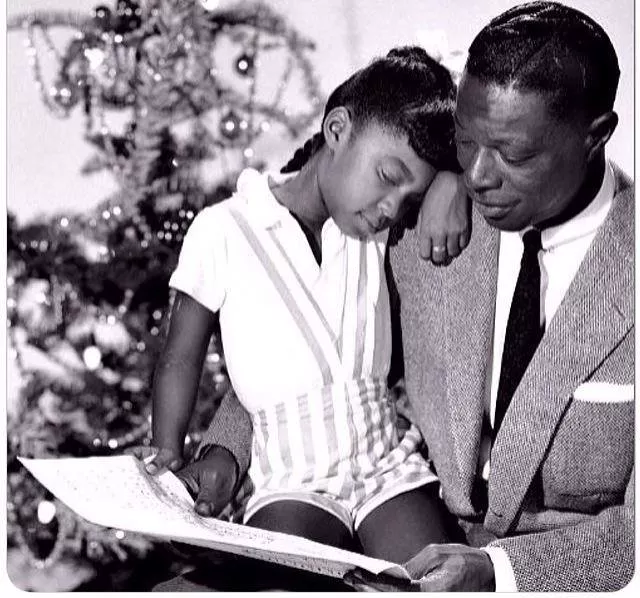 Cole, on the lap of her legendary father, a man she would grow to be considered equal to as a vocalist - VIA FACEBOOK