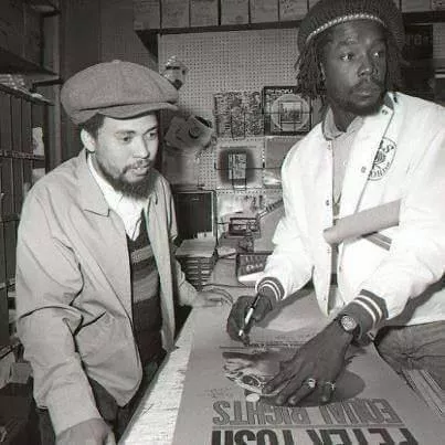 Peter Tosh (right) signing a poster for a fan. - FACEBOOK